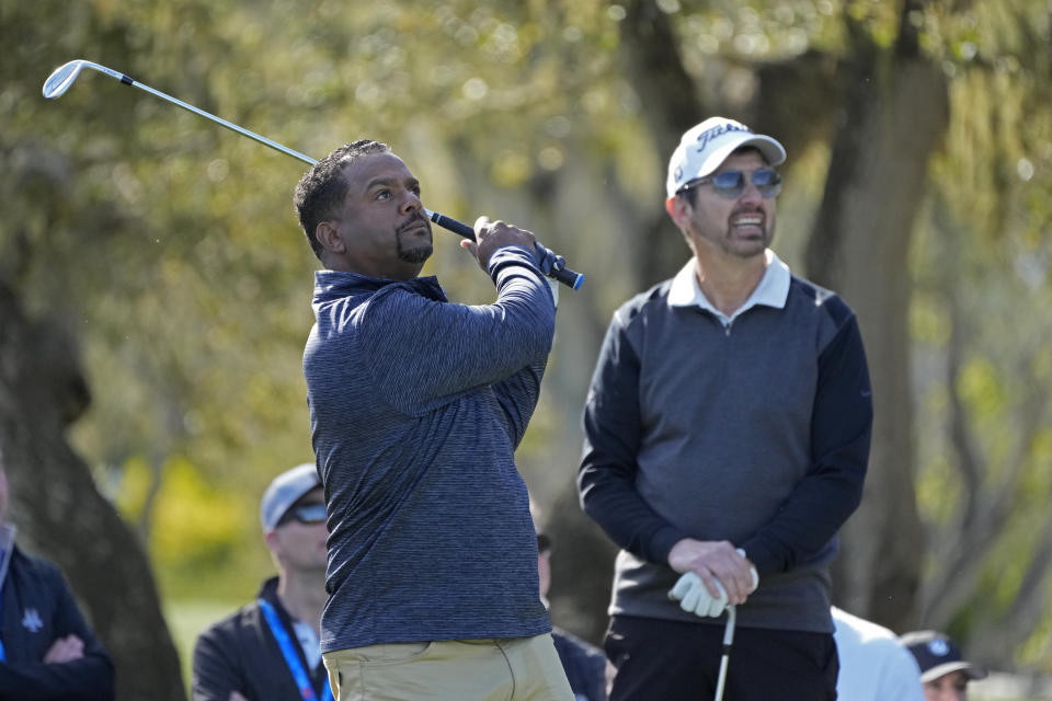 Alfonso Ribeiro, left, follows his shot from a tee as Ray Romano looks on during the celebrity challenge event of the AT&T Pebble Beach Pro-Am golf tournament in Pebble Beach, Calif., Wednesday, Feb. 1, 2023. (AP Photo/Eric Risberg)