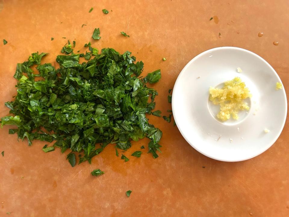 Chopped parsley and garlic for Giada De Laurentiis' Bucatini All'Amatriciana with Smoked Meatballs