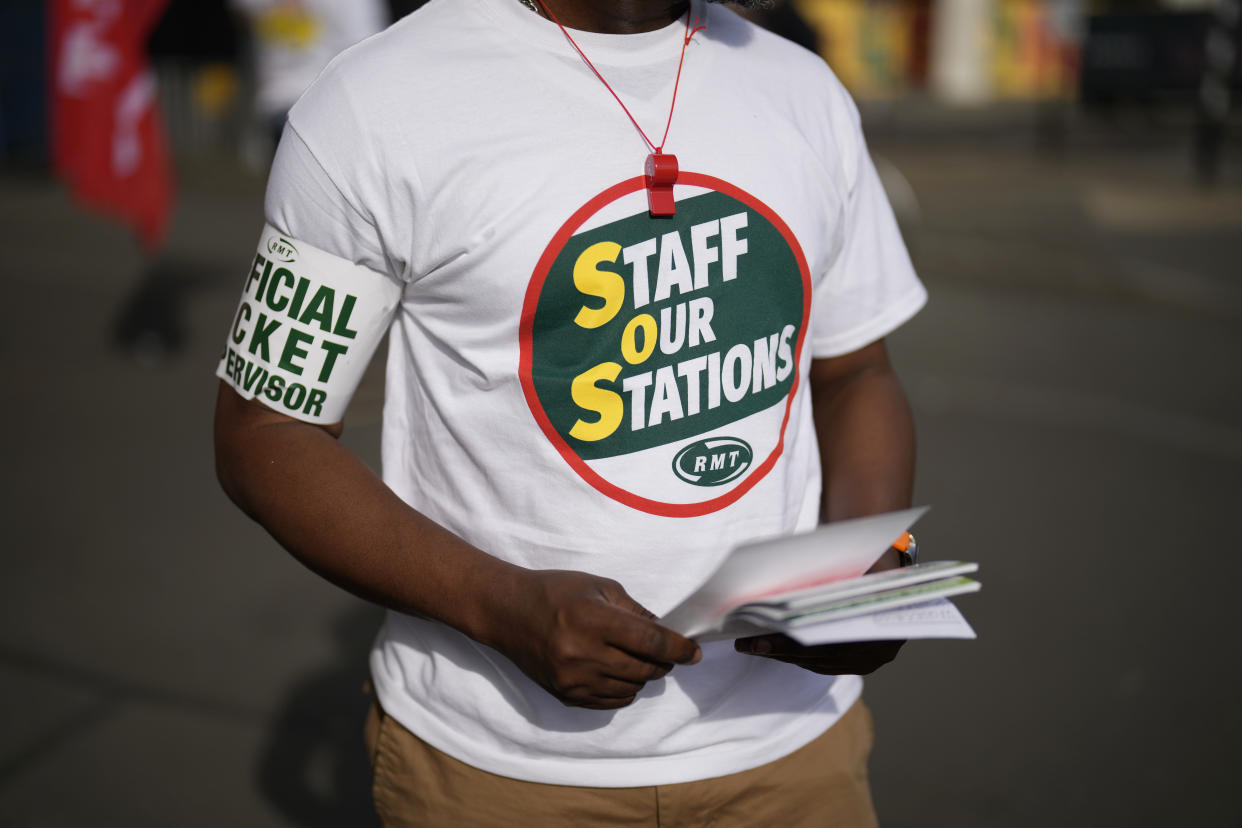 A worker stands on a picket line outside Waterloo railway station, in London, Tuesday, June 21, 2022. Tens of thousands of railway workers have walked off the job in Britain, bringing the train network to a crawl in the country’s biggest transit strike in three decades. (AP Photo/Matt Dunham)