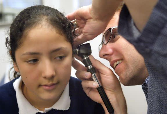 A doctor performs a physical exam on a fourth-grader in Cicero, Illinois.