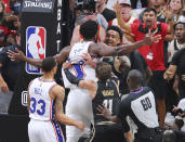 Philadelphia 76ers Joel Embiid, top center left, is called for an offensive foul against Atlanta Hawks forward John Collins, who was called for a technical foul, as they break into an altercation while an official, Hawks' Trae Young (11) and 76ers' George Hill (33) move in to break it up during the fourth quarter of Game 6 of an NBA basketball Eastern Conference semifinal series Friday, Jun 18, 2021, in Atlanta. (Curtis Compton/Atlanta Journal-Constitution via AP)