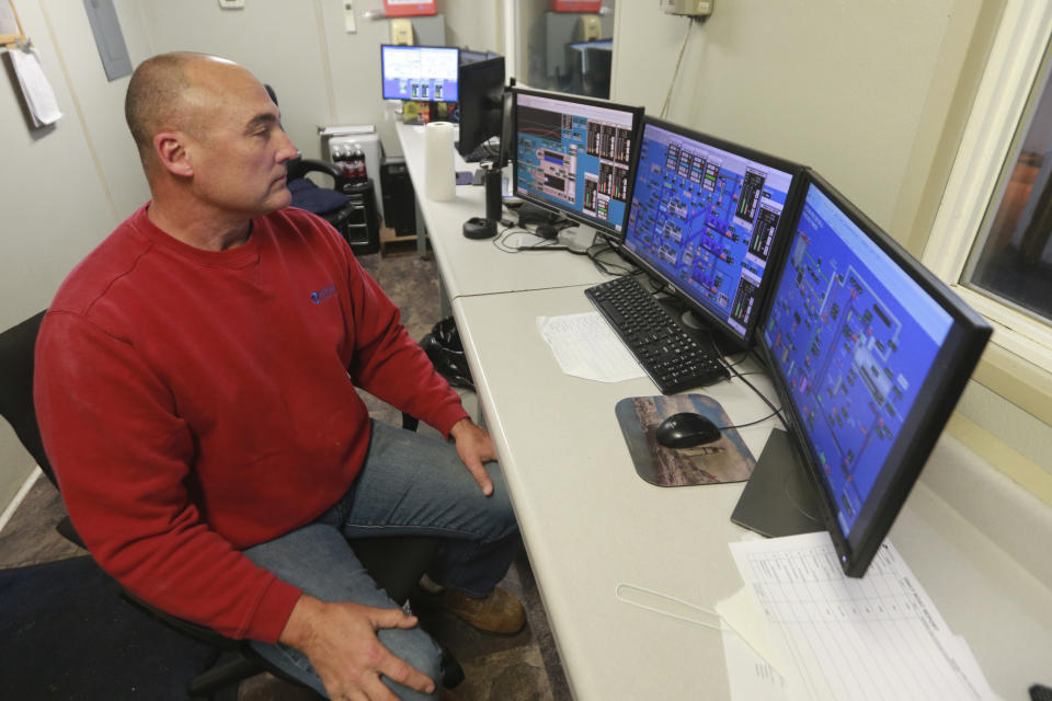 Omega Protein's Operations Manager, Monty Deihl, looks over control room screens at the menhaden processing plant on Cockrell's Creek in Reedville, Va., Tuesday, Nov. 26, 2019. The last east coast fishery now produces fish oil for health supplements and faces a possible moratorium over concerns about overfishing in the Chesapeake Bay. (AP Photo/Steve Helber)