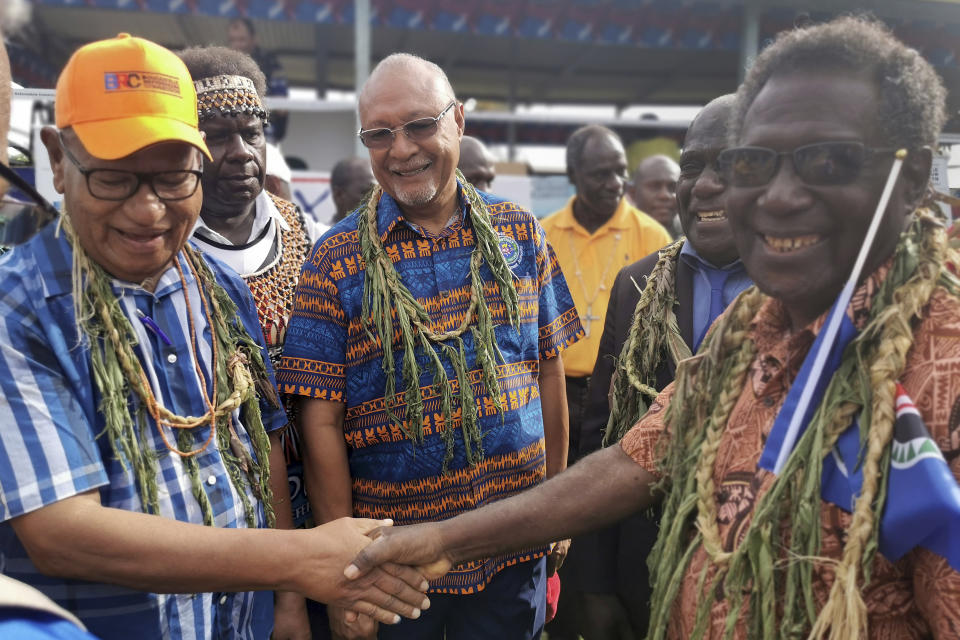 John Momis, left, president of the Autonomous Region of Bougainville, shakes hands with Bougainville MP William Nakin, right, in Buka, Papua New Guinea, Saturday, Nov. 23, 2019, during a historic referendum to decide if they want to become the world's newest nation by gaining independence from Papua New Guinea. (Post Courier via AP)