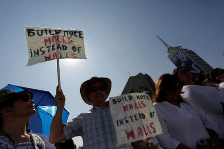 A demonstrator holds placards during a protest against U.S. President Donald Trump's proposed border wall and to call for unity, in Monterrey, Mexico, February 12, 2017. REUTERS/Daniel Becerril