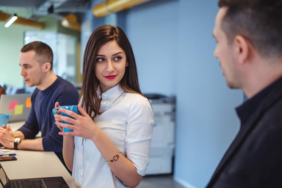 Girl looking at her colleague with love in her eyes while he is talking