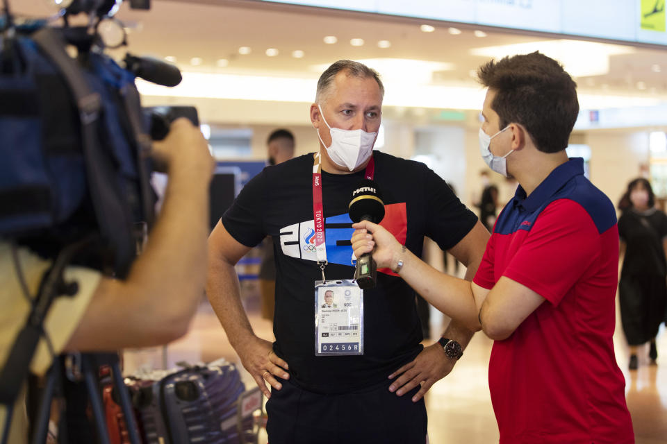 Stanislav Pozdnyakov, president of the Russian Olympic Committee, responds to a Russian reporter's question as he arrives for the Tokyo 2020 Summer Olympic and Paralympic Games at Haneda international airport in Tokyo on Sunday, July 18, 2021. (AP Photo/Hiro Komae)