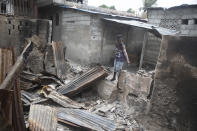 A man shows journalists how his home was set on fire during clashes between armed gangs in the Butte Boyer neighborhood of Port-au-Prince, Haiti, Friday, May 13, 2022. As police try to contain the gang violence, AP journalists visited the Butte Boyer neighborhood, where the smell of charred homes and decaying bodies spread for several blocks. (AP Photo/Odelyn Joseph)