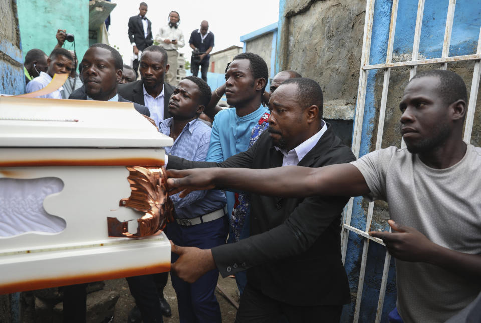 People push the coffin of mission director Judes Montis, killed by gangs alongside two of his U.S. missionary members, to the cemetery after his funeral ceremony in Port-au-Prince, Haiti, Tuesday, May 28, 2024. The service also honored the lives of Davy and Natalie Lloyd, featured on the photo on the back of the hearse, a married couple in their early 20s who was with Montis when gunmen ambushed them on Thursday night, May 23, as they left a youth group activity held at a local church. (AP Photo/Odelyn Joseph)