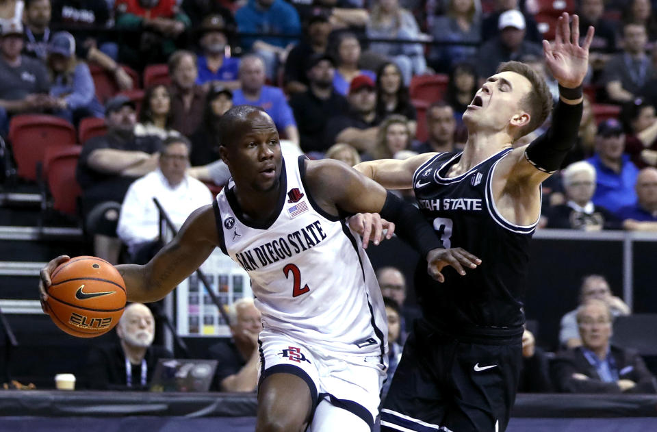 San Diego State guard Adam Seiko (2) drives against Utah State guard Steven Ashworth (3) during the first half of an NCAA college basketball game for the men's Mountain West Tournament championship Saturday, March 11, 2023, in Las Vegas. (AP Photo/Steve Marcus)