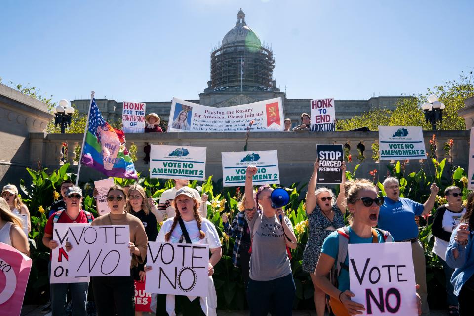 Counterprotesters hold signs in front of a rally encouraging voters to vote yes on Amendment 2, which would add a permanent abortion ban to Kentucky&#39;s state constitution, on the steps of the Kentucky State Capitol in Frankfort in October. 