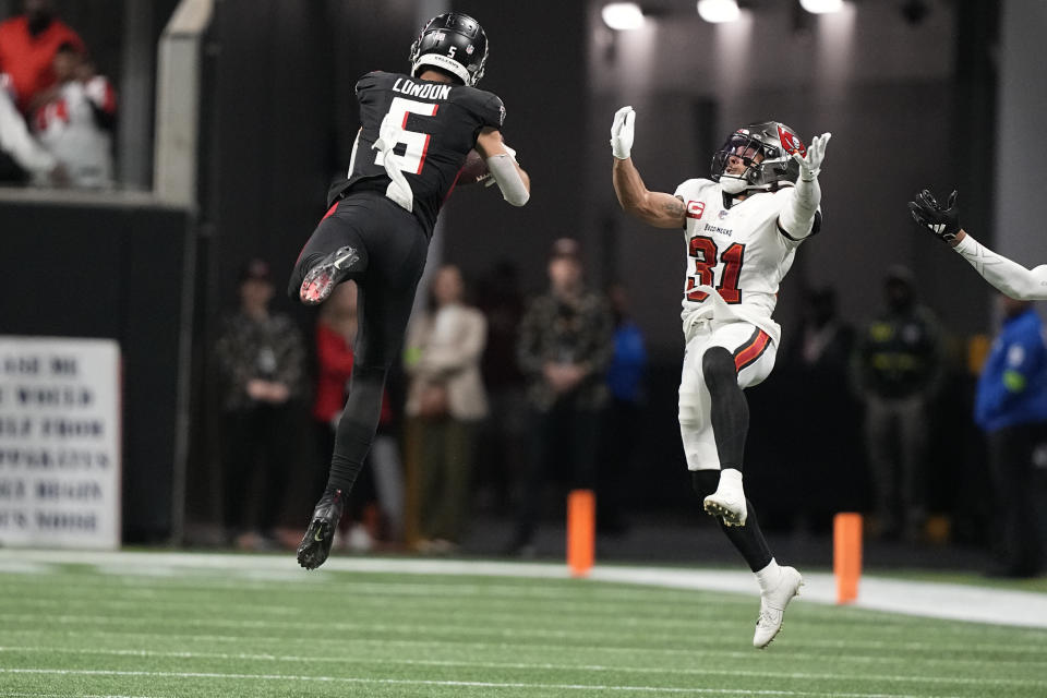 Atlanta Falcons wide receiver Drake London (5) makes a catch as Tampa Bay Buccaneers safety Antoine Winfield Jr. (31) defends during the second half of an NFL football game, Sunday, Dec. 10, 2023, in Atlanta. (AP Photo/Brynn Anderson)