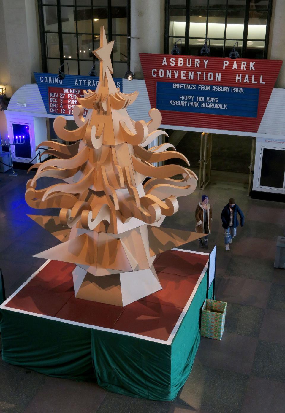 "The Giving Tree," a 17-foot cardboard Christmas Tree in the Grand Arcade in the Asbury Park Boardwalk by Mike "Porkchop" La Vallee and Bradley Hoffer is shown Wednesday, December 1, 2021.  The art project is presented by the community arts non-profit the Wooden Walls Project and the Asbury Park Boardwalk.