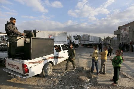 Forces loyal to Syria's president Bashar al-Assad stand by as an aid convoy of the Syrian Arab Red Crescent enters the Wafideen Camp, which is controlled by Syrian government forces, to deliver aid into the rebel-held besieged Douma neighborhood of Damascus, Syria March 4, 2016. REUTERS/Omar Sanadiki