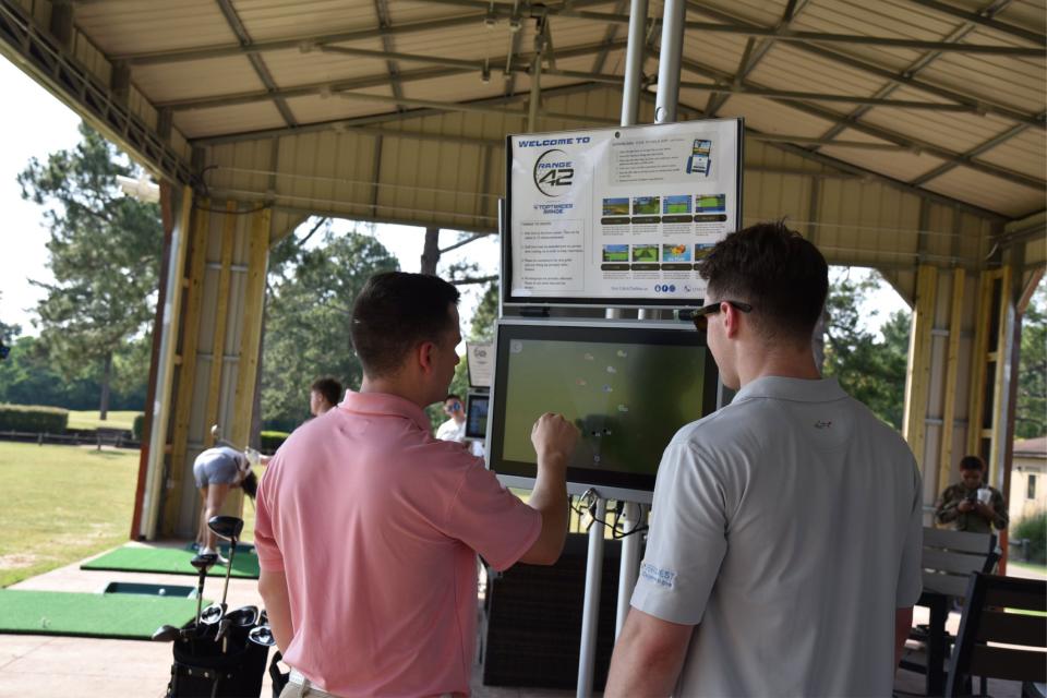 42nd Air Base Wing airmen play Toptracer golf at Range 42 during a Toptracer soft opening May 18, 2022. The driving range has modernized the golfing experience through Toptracer technology that will provide six globally connected bays with a wide variety of games for Airmen, Guardians, and families.