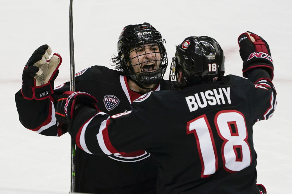 St. Cloud State's Joe Molenaar, left, celebrates with Brendan Bushy (18) after scoring the tying goal against Minnesota State during the third period of an NCAA men's Frozen Four hockey semifinal in Pittsburgh, Thursday, April 8, 2021. St. Cloud State won 5-4 to advance to the championship game Saturday. (AP Photo/Keith Srakocic)