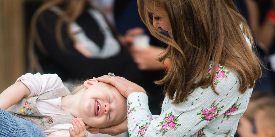 <p>The duchess giggles with a young child at the Back to Nature festival at RHS Garden Wisley.</p>