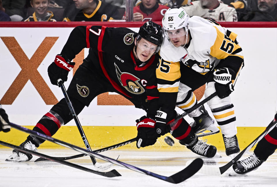 Ottawa Senators left wing Brady Tkachuk (7) and Pittsburgh Penguins center Noel Acciari (55) watch the puck during the second period of an NHL hockey game in Ottawa, Ontario, on Saturday, Dec. 23, 2023. (Justin Tang/The Canadian Press via AP)