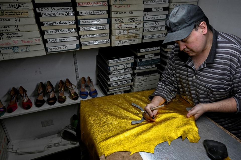 Luis Beron, zapatero especializado en la confección de zapatos para bailar tango, trabaja en su taller de la tienda “Comme il faut” de Buenos Aires. (Foto: Luis Robayo/AFP)