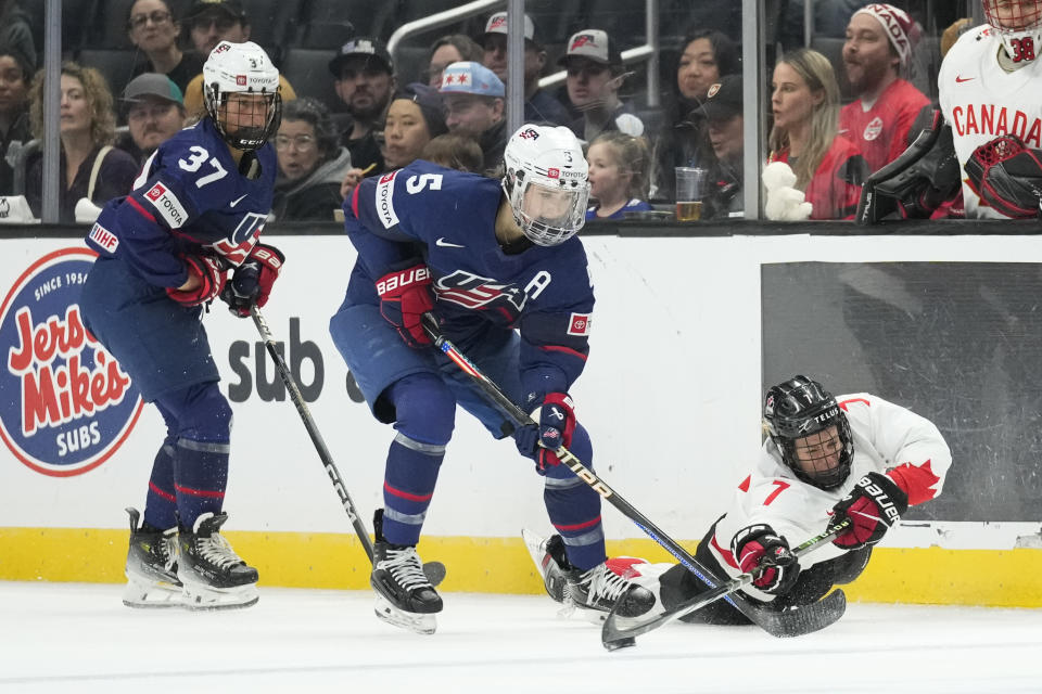 Canada forward Laura Stacey (7) reaches for the puck while defended by United States defender Megan Keller (5) during the second period of a rivalry series women's hockey game Saturday, Nov. 11, 2023, in Los Angeles. (AP Photo/Ashley Landis)