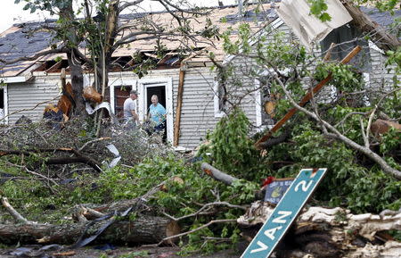 A man and woman talk at the entrance of a house that was destroyed after a tornado swept through the area the previous night in Van, Texas May 11, 2015. REUTERS/Mike Stone