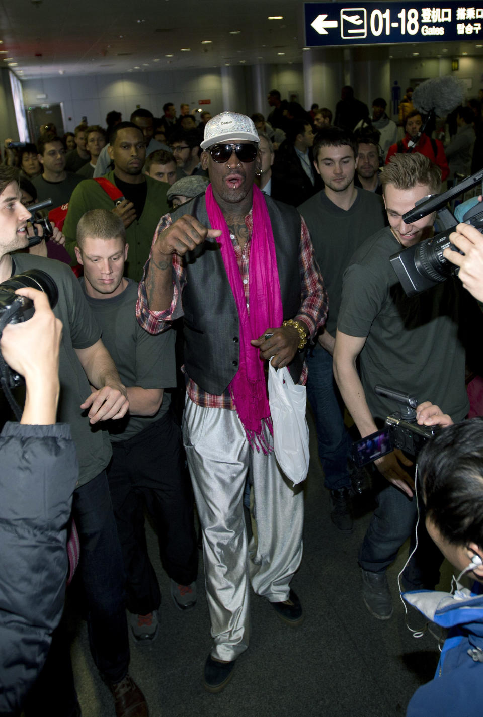 Dennis Rodman, ex estrella de la NBA, habla mientras los medios lo acorralan en el Aeropuerto Internacional de Beijing el lunes 6 de enero de 2014. Rodman llegó el lunes a Corea del Norte al frente de un equipo de ex estrellas de la NBA para un partido de exhibicion contra la escuadra nacional norcoreana el miércoles, el día del cumpleaños del líder Kim Jong Un. (Foto AP/Andy Wong)