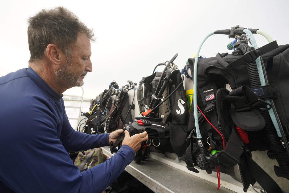 University of Miami's Rosenstiel School of Marine & Atmospheric Science Associate Professor Diego Lirman prepares his dive gear before a night dive to check on coral spawning, Monday, Aug. 15, 2022, in Key Biscayne, Fla. A group of students and scientists were hoping to observe the coral spawn and collect their eggs and sperm, called gametes, to take back to the lab to hopefully fertilize and create new coral that will later be transplanted to help repopulate part of the Florida Reef Tract. (AP Photo/Wilfredo Lee)