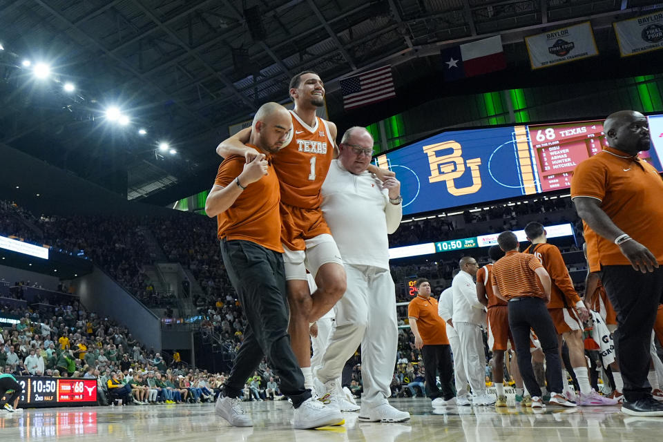 Texas's Dylan Disu (1) is helped off the court during the second half of an NCAA college basketball game against Baylor, Monday, March 4, 2024, in Waco, Texas. Baylor won 93-85. Disu did not return to the game. (AP Photo/Julio Cortez)