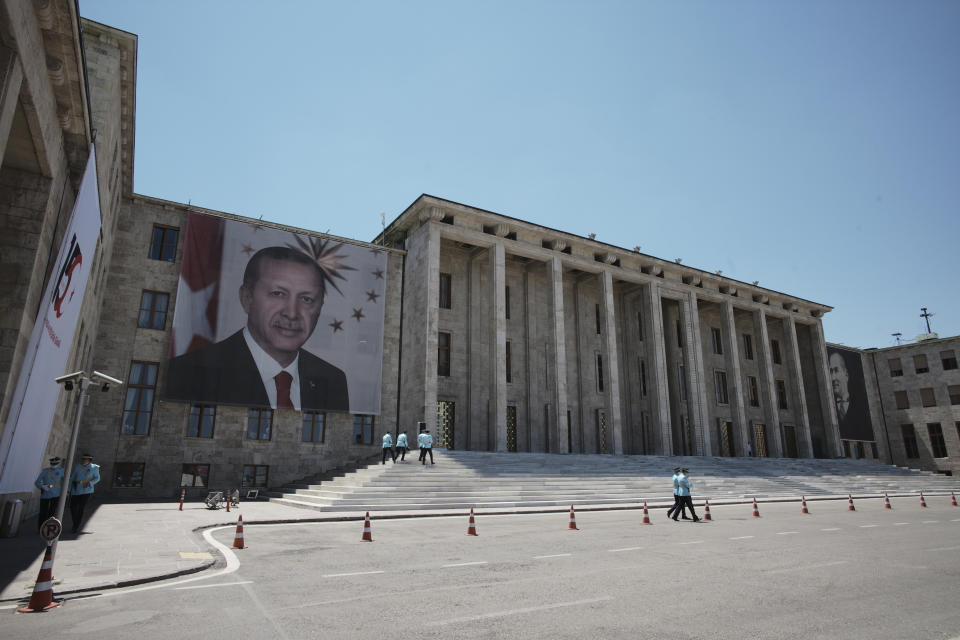 Presidential honour guard officers walk as Turkey's President Recep Tayyip Erdogan attends a ceremony at the parliament decorated with the portraits of Turkey's founder Mustafa Kemal AStaturk, right, and Erdogan, in the capital Ankara, Turkey, Thursday, July 15, 2021. Turkey on Thursday marked the fifth anniversary of a failed coup attempt against the government, with a series of events commemorating victims who died trying to quash the uprising. (AP Photo/Burhan Ozbilici)