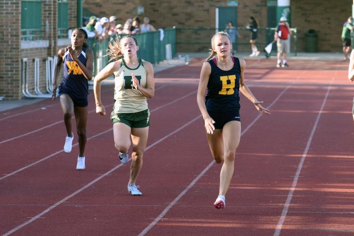 Hartland&#39;s Emmy Sargeant (right) completes a sweep of three sprint events by edging Howell&#39;s Aliana Pietila (center) in the 200-meter dash at the KLAA track and field meet Friday, May 13, 2022 at Novi.