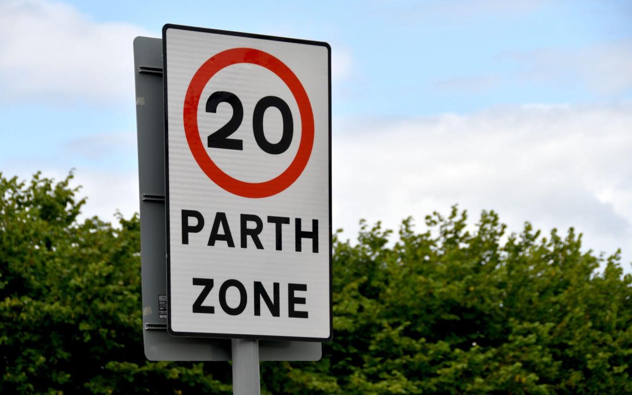 Bilingual road sign showing a 20 mph speed limit at the approach to a village in Wales