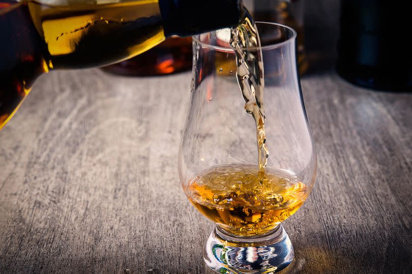 Whisky being poured into a glass from a bottle