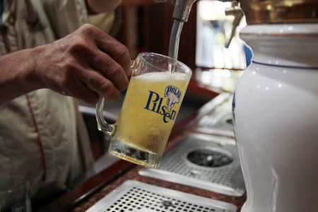 Un empleado sirve una cerveza en una cervecería de Polar en Maracaibo, Venezuela, oct 14, 2016. Asfixiados por la falta de insumos, los dos mayores fabricantes de cerveza en Venezuela, Polar y Regional, reclamaron públicamente el año pasado al Gobierno por el retraso en la asignación de dólares, indispensables para importar lúpulo, cebada y hojalata. REUTERS/Isaac Urrutia IMAGEN SOLO PARA USO EDITORIAL