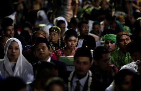 Couples take part in a mass wedding organised by the city government as part of New Year's Eve celebrations in Jakarta, Indonesia, December 31, 2017. REUTERS/Darren Whiteside