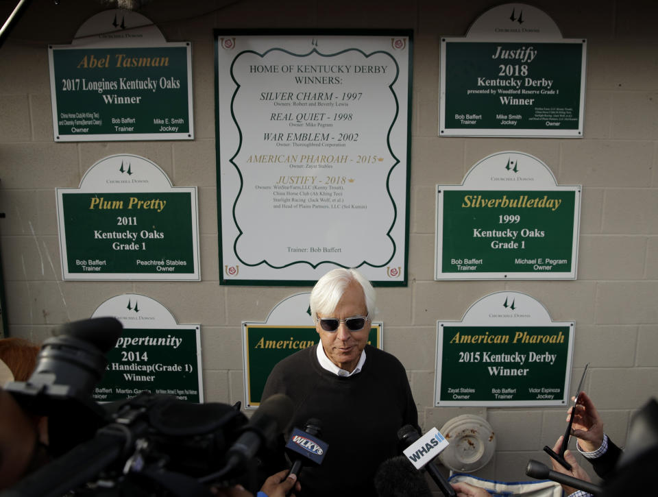 FILE - Trainer Bob Baffert talks to the media before a workout at Churchill Downs Thursday, May 2, 2019, in Louisville, Ky. The 145th running of the Kentucky Derby is scheduled for Saturday, May 4. Baffert won't be saddling any horses in the Kentucky Derby this weekend. The winner of a record-tying six Derbies will miss the race for the second straight year while completing a two-year suspension issued by Churchill Downs Inc. (AP Photo/Charlie Riedel, File)