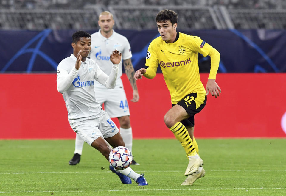 Dortmund's Giovanni Reyna, right, and Zenit's Wilmar Barrios, left, challenge for the ball during the Champions League group F soccer match between Borussia Dortmund and Zenit Saint Petersburg in Dortmund, Germany, Wednesday, Oct. 28, 2020. (Bernd Thissen/Pool via AP)