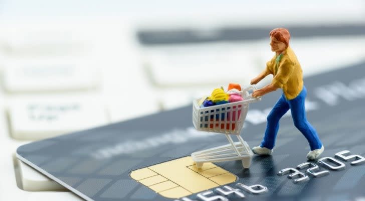 a figure of a shopper standing on top of a credit card