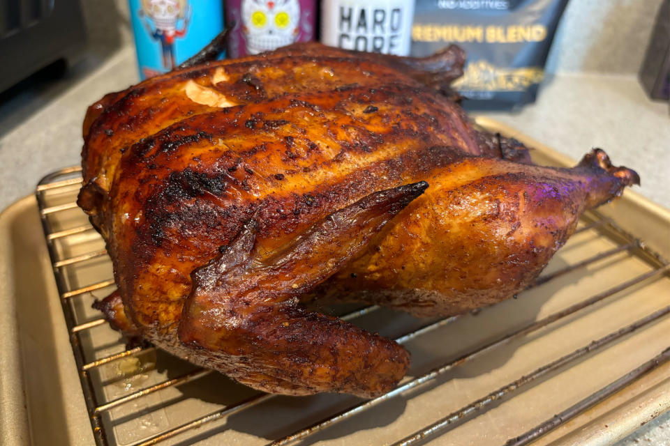 <p>A whole smoked chicken sitting on a baking sheet after being smoked inside the GE Profile Smart Indoor Smoker.</p>
