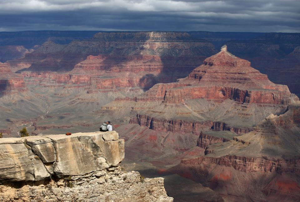 Collin Carter and Emma Griggs (right), two seasonal employees at Crested Butte Mountain Resort ski resort in Colorado kiss at Mather Point in Grand Canyon National Park on Mar. 18, 2020.