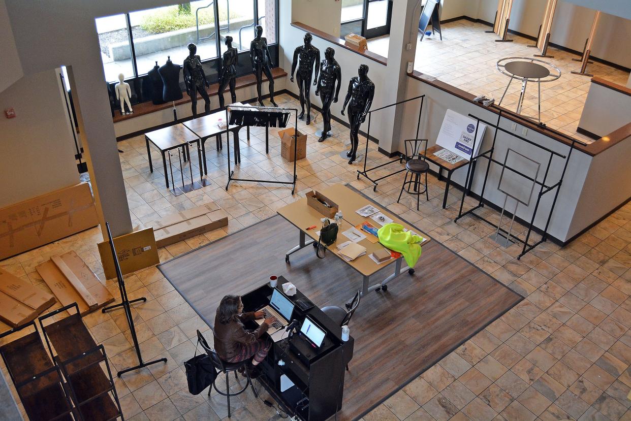 Mannequins, clothing racks and other product displays are now in the Shops at Sharp End space at 500 E. Walut St. Retail manager Tanisha Simpson, seated, works on loading inventory to the retail business incubator's point-of-sale system. A mid-January public opening is likely.