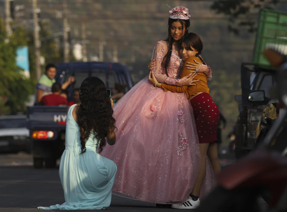 Una joven que celebra sus 15 años posa para una foto en la calle principal de La Campanera, durante la celebración en una iglesia evangélica en Soyapango, El Salvador, el domingo 5 de marzo de 2023. (AP Foto/Salvador Meléndez)