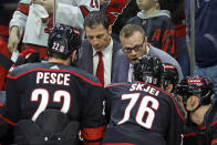 Carolina Hurricanes assistant coach Tim Gleason, upper right, speaks to the defense with head coach Rod Brind'Amour, upper left, nearby during the third period in Game 1 of an NHL hockey Stanley Cup first-round playoff series against the New York Islanders in Raleigh, N.C., Saturday, April 20, 2024. (AP Photo/Karl B DeBlaker)