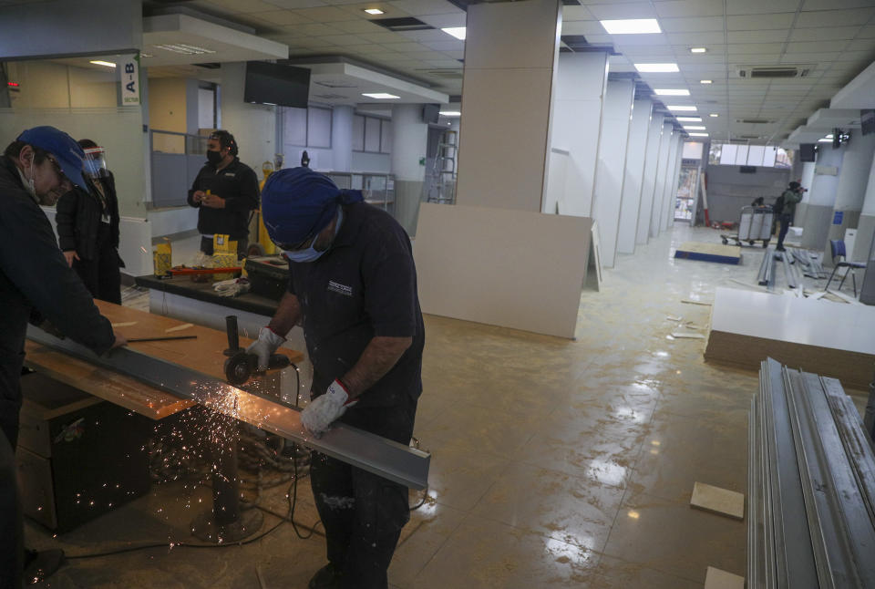 Trabajadores trasforman la sala de admisiones de la clínica de la Universidad de Chile en un espacio de cuidados intensivos para tratar pacientes contagiados de COVID-19, en Santiago, Chile, el martes 2 de junio de 2020. (AP Foto/Esteban Felix)