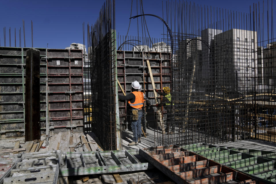 Palestinian laborers work at a construction site in a new housing project in Har Homa, an Israeli settlement in east Jerusalem that Israel considers a neighborhood of its capital, Wednesday, July 6, 2022. For more than two years, the Biden administration has said that Palestinians are entitled to the same measure of “freedom, security and prosperity” enjoyed by Israelis. Instead, they've gotten U.S. aid and permits to work inside Israel and its Jewish settlements. The inconsistency is likely to come up when President Joe Biden visits Israel and the occupied West Bank this week for the first time since assuming office. (AP Photo/Mahmoud Illean)