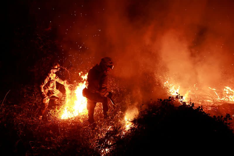 Firefighters tackle a blaze near the village of Piedrafita during an outbreak of wildfires in northern Spain's Asturias region