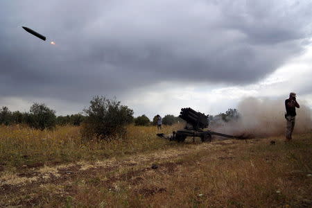 Free Syrian Army fighters cover their ears as they fire a rocket towards forces loyal to Syria's President Bashar Al-Assad in Deraa countryside May 11, 2015. REUTERS/Alaa Al-Faqir