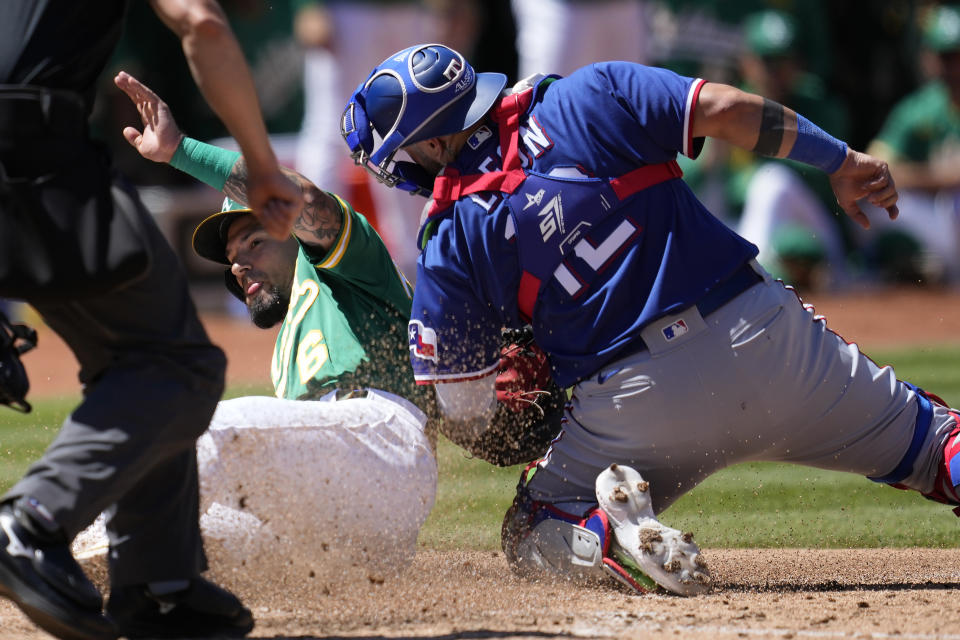 Texas Rangers catcher Sandy Leon, right, tags out Oakland Athletics' Jace Peterson at home during the seventh inning of a baseball game in Oakland, Calif., Saturday, May 13, 2023. (AP Photo/Jeff Chiu)