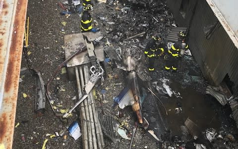 Firefighters work on the roof of 787 Seventh Avenue at 51st Street after a helicopter crashed there  - Credit: Getty