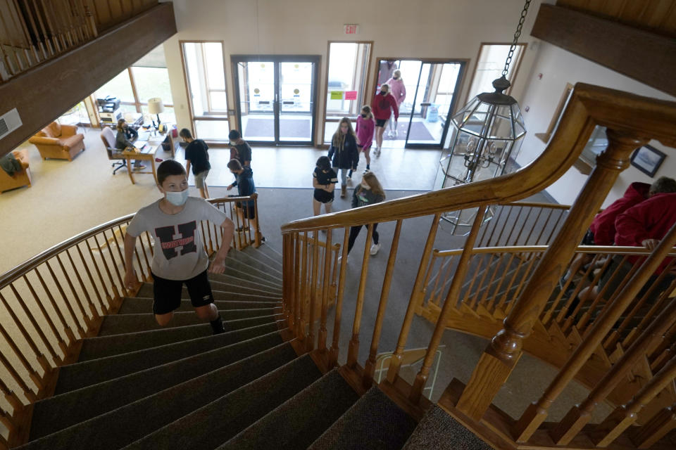 Students from Hesston Middle School enter the Cross Winds Convention Center in Hesston, Kan., Friday, Nov. 6, 2020. The convention center provides the ability to social distance while attending classes in person. (AP Photo/Orlin Wagner)