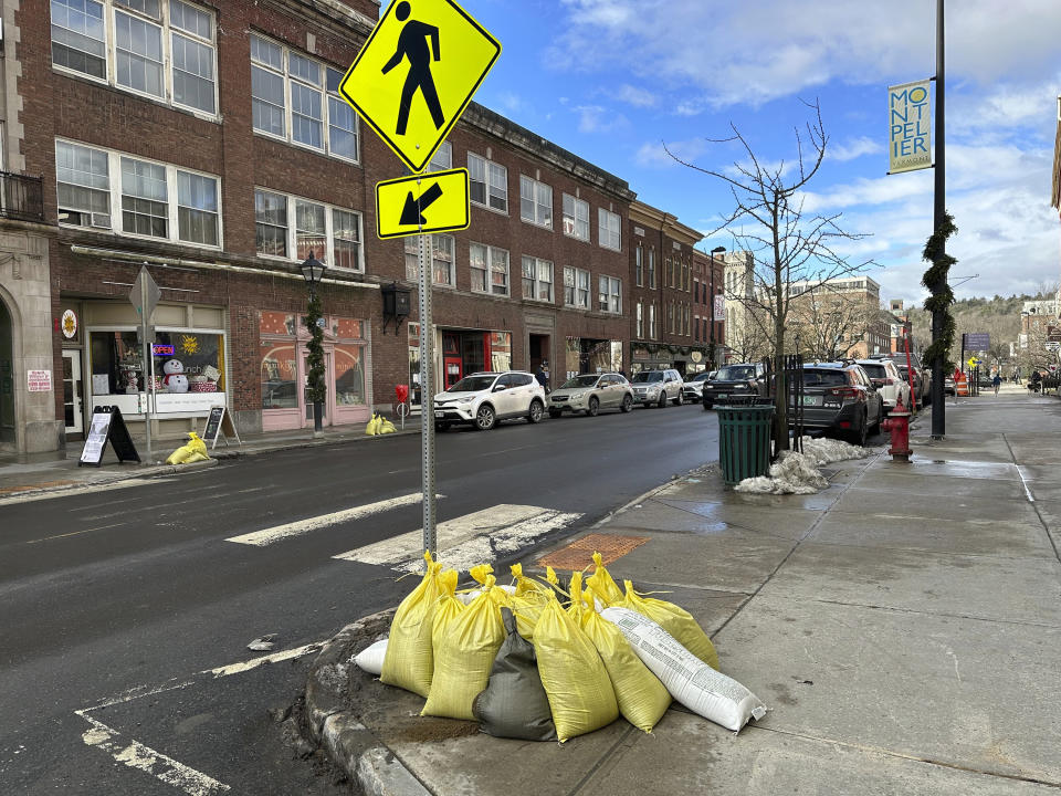 Sand bags sit on a street in Montpelier, Vt., on Tuesday, Dec. 19, 2023, a day after the threat of flooding hit the city again. Many communities were saturated by rainfall. Some towns in Vermont, which had suffered major flooding from a storm in July, were seeing more flood damage. (AP Photo/ Lisa Rathke)