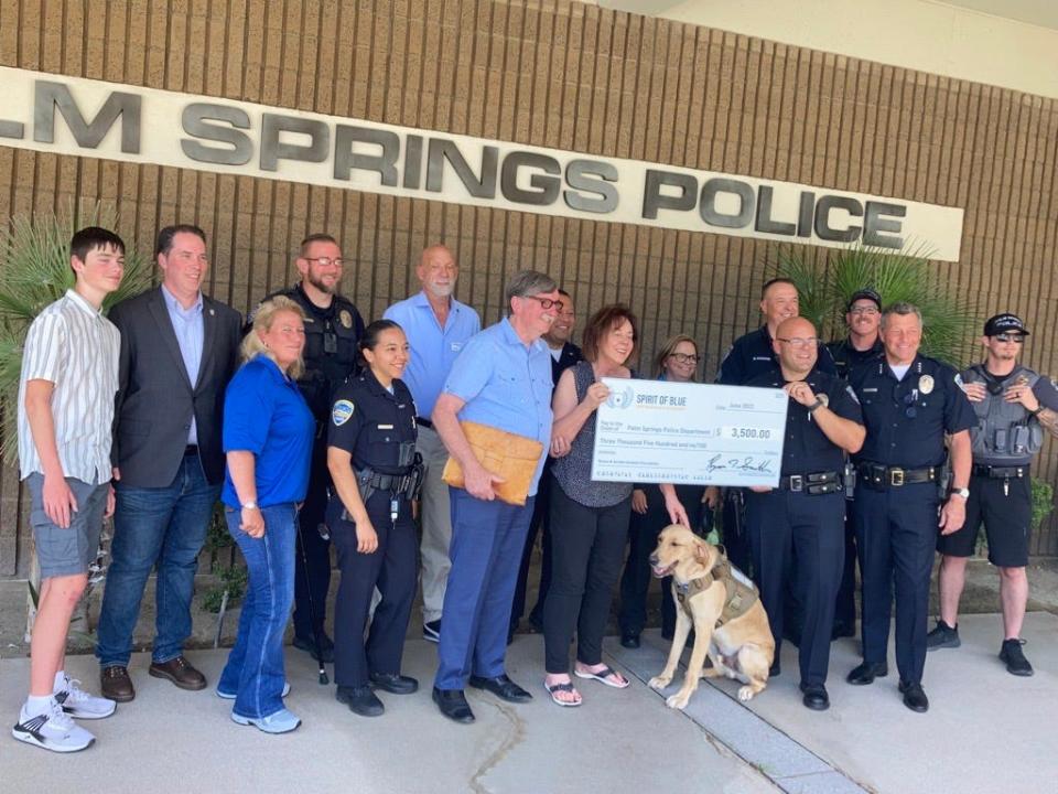 Renee Graham, holding left side of check, and Gustavo Araiza, holding right side, hold a $3,500 check Renee and her husband, Gordon, donated to the Palm Springs Police. The money was to be given to Guide Dogs of the Desert to pay for the organization to train a new guide dog to replace Finley.